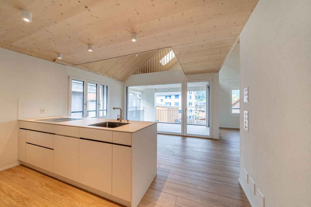 5.5 Zimmer Neubau Maisonettewohnung über dem Nebel in Einsiedeln - Kochinsel mit Essbereich mit Zugang Loggia