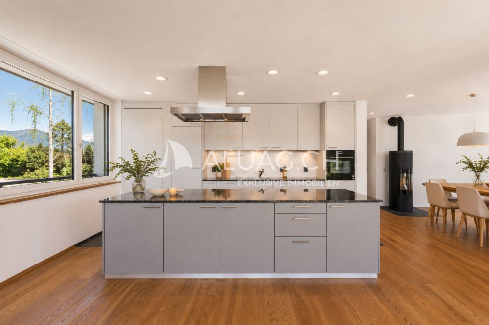 NEUBAUWOHNUNG MIT MODERNEM WOHNKONZEPT - Lichtdurchflutete, moderne Küche mit Kochinsel und höhenverstellbarem Dampfabzug