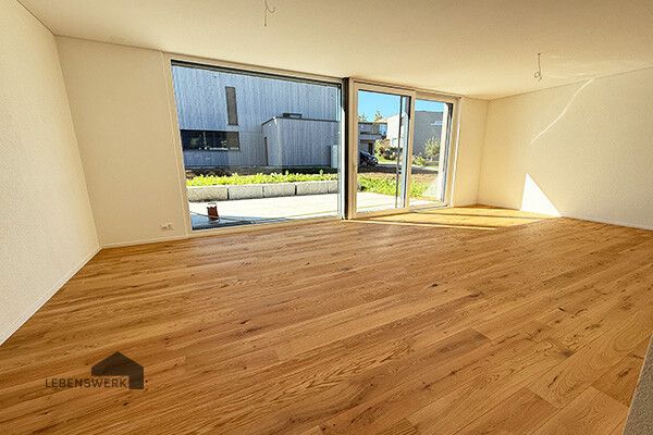 Wo Kinder lachen und Eltern ankommen. Ein Zuhause mit Maisonette-Chara - Grosszügiger Wohnbereich mit Eichenparkett und direktem Gartenzugang