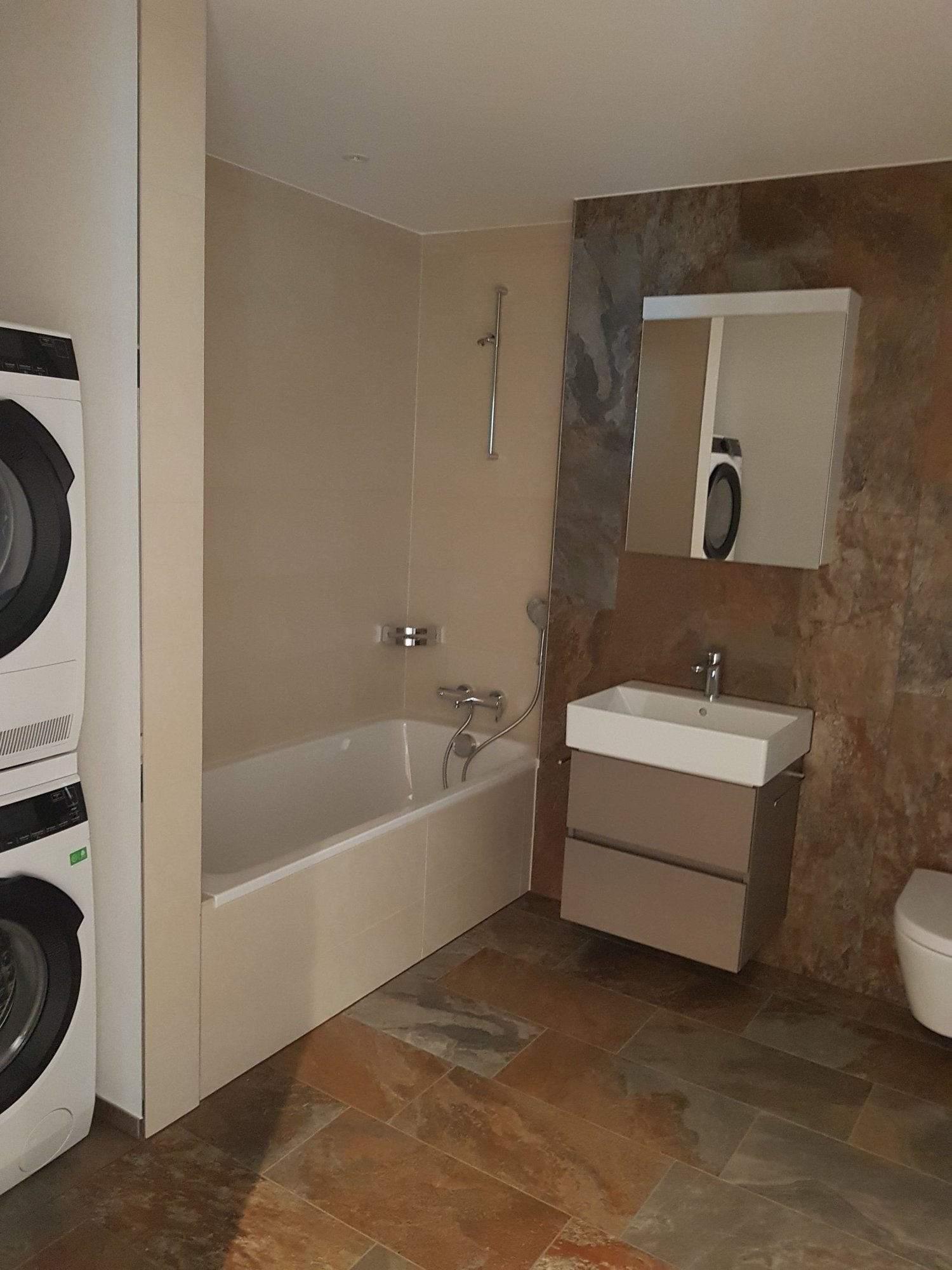 4,5 Zimmerwohnung gleich am Bahnhof Sennhof-Winterthur - Funktionales Badezimmer mit Wanne, Dusche und integrierter Waschmaschine