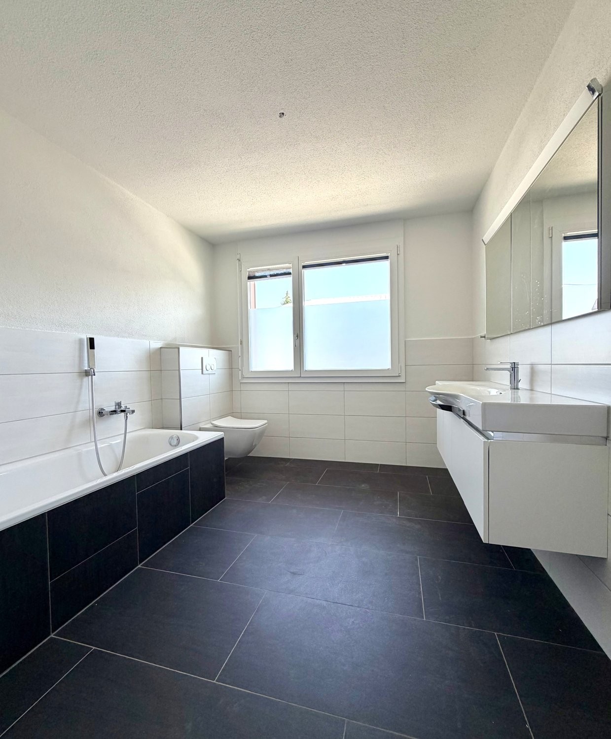 Grosszügige 5.5-Zimmerwohnung mit Terrasse, Bergsicht und Schwedenofen - Bad mit Badewanne