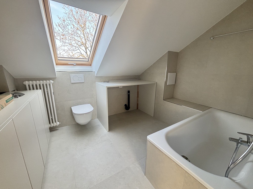 Smart Wohnen in heller Maisonette-Dachwohnung - Badezimmer mit Badewanne, Waschmaschine und Tumbler